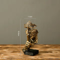 Estatueta abstrata "O Silêncio é Ouro" de resina.
