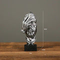 Estatueta abstrata "O Silêncio é Ouro" de resina.
