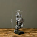 Estatueta abstrata "O Silêncio é Ouro" de resina.