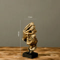 Estatueta abstrata "O Silêncio é Ouro" de resina.